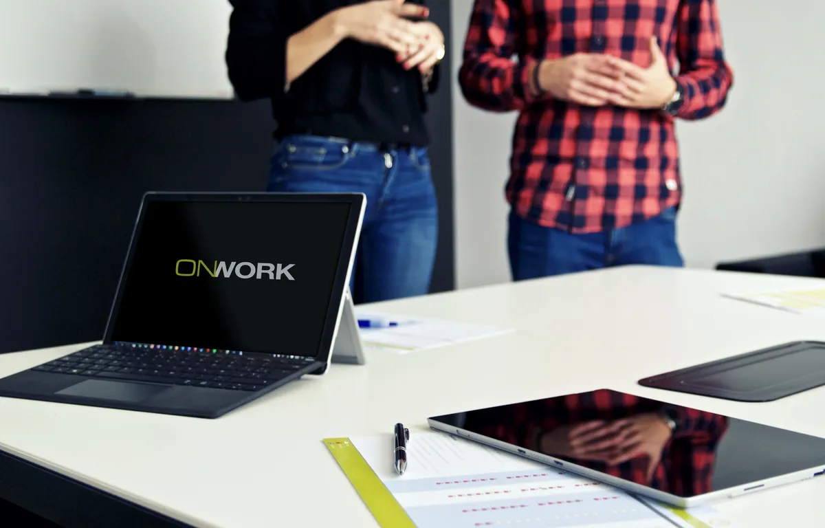 Equipo OnWork trabajando con un portátil con el logo de la empresa